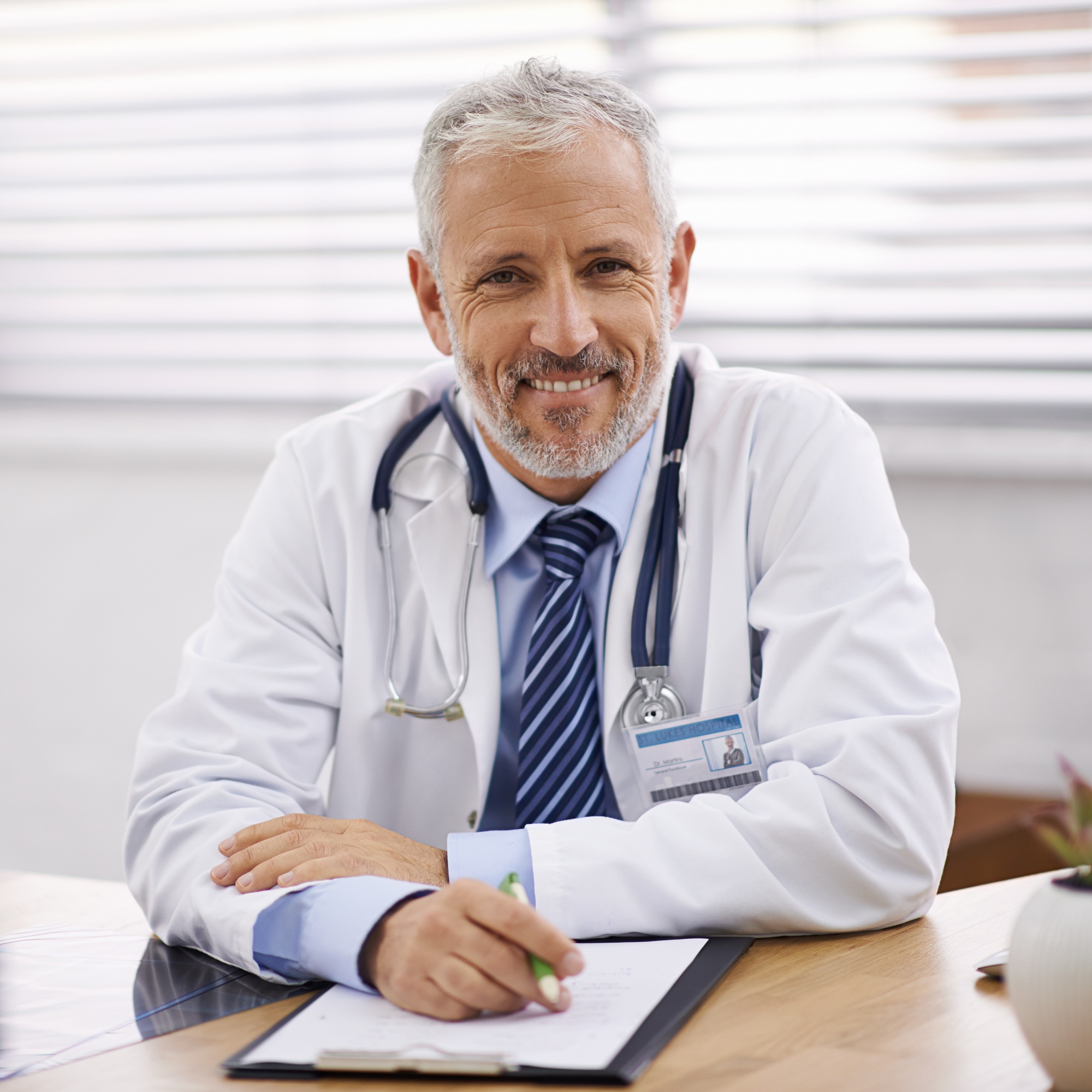 Healthcare you can trust. Portrait of a mature male doctor sitting at his desk.